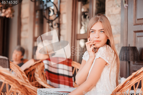 Image of Young beautiful smiling woman talking on cell phone