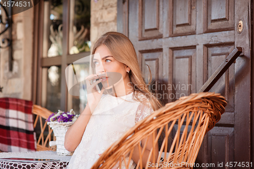 Image of Young beautiful smiling woman talking on cell phone