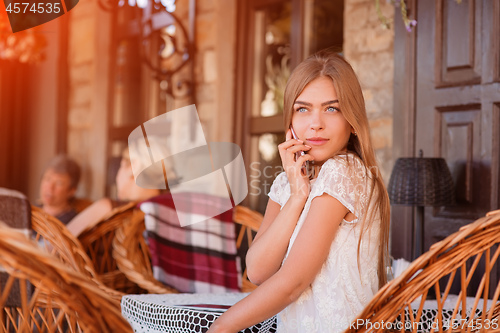 Image of Young beautiful smiling woman talking on cell phone