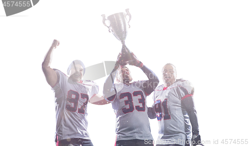 Image of american football team with trophy celebrating victory