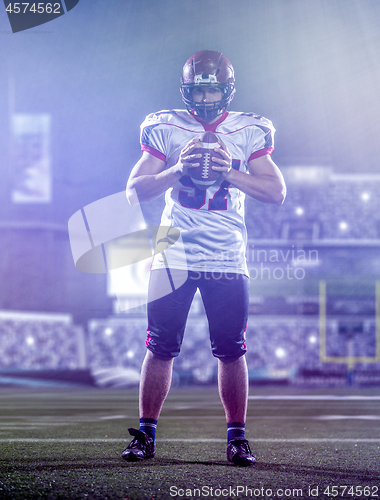 Image of portrait of confident American football player standing on the f