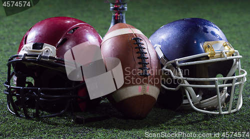 Image of closeup of american football,helmets and trophy