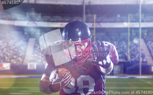 Image of American football player holding ball while running on field