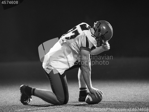 Image of American football player starting football game