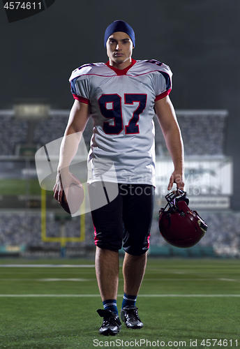 Image of portrait of young confident American football player walking thr