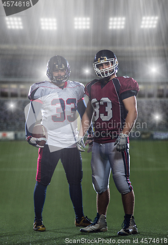 Image of Two American football players standing  on the field