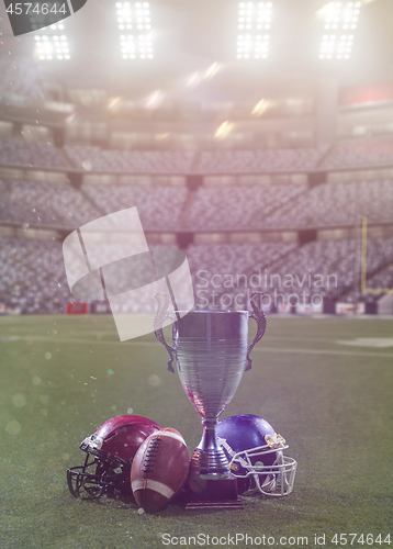 Image of closeup of american football,helmets and trophy