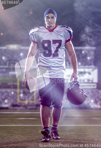 Image of portrait of young confident American football player walking thr