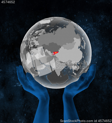 Image of Kyrgyzstan on globe in hands in space