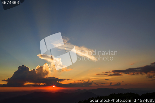 Image of Sunset orange sun, rays over the mountains