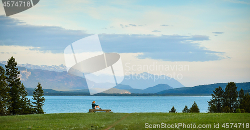 Image of Woman enjoys the mountain and lake view