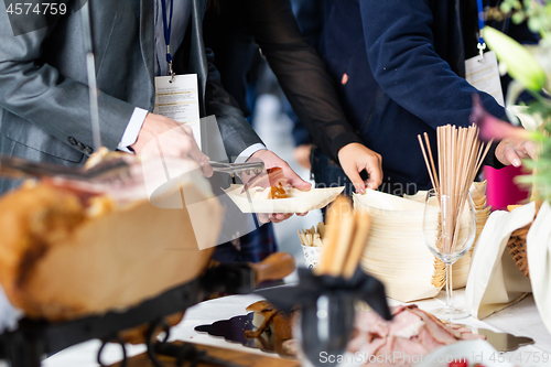 Image of Businesspeople at banquet lunch break at business conference meeting. Assortment of food and drinks.