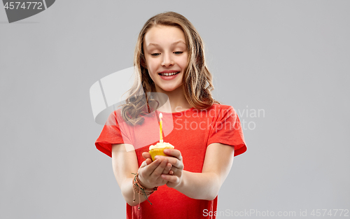 Image of teenage girl with one candle on birthday cupcake