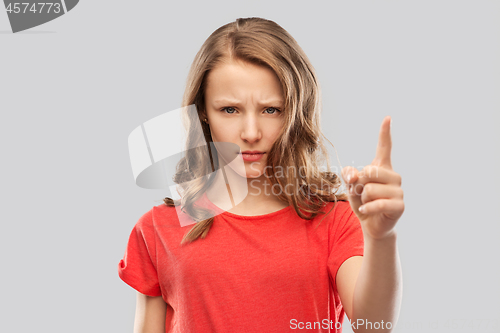Image of angry frowning teenage girl pointing finger up