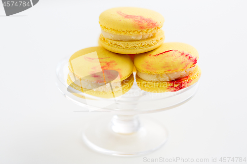 Image of lemon yellow macarons on glass confectionery stand