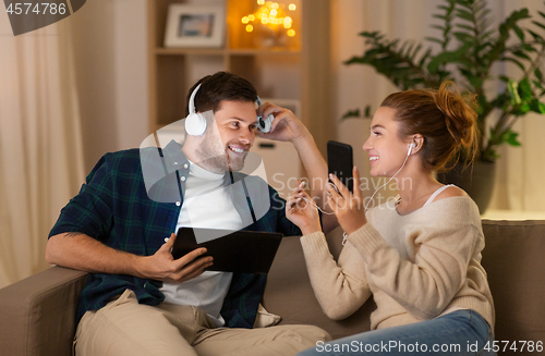 Image of couple with gadgets listening to music at home