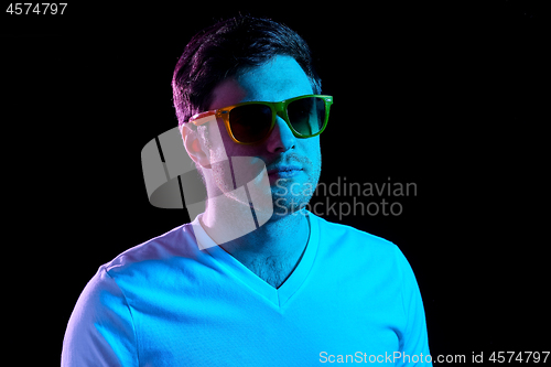 Image of man in sunglasses over ultra violet neon lights