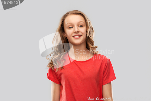 Image of smiling teenage girl in red t-shirt over grey
