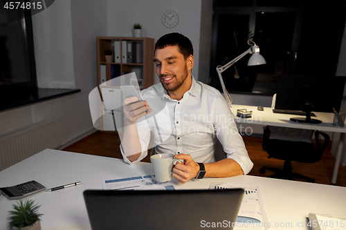 Image of businessman with smartphone and coffee at office