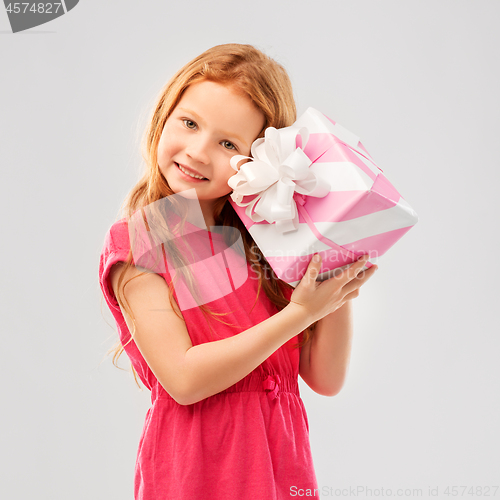 Image of lovely red haired girl with birthday gift