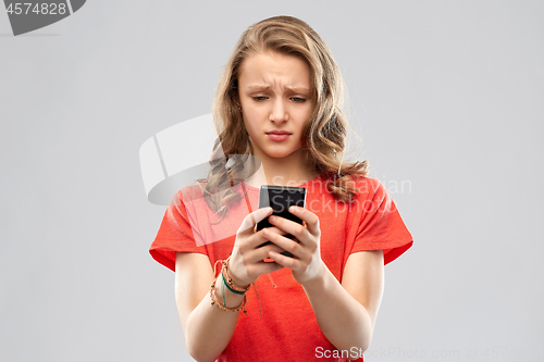 Image of sad teenage girl using smartphone