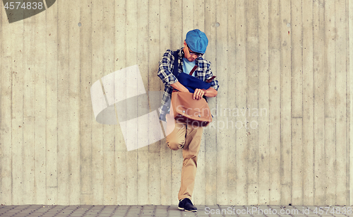 Image of hipster man looking for something in his bag