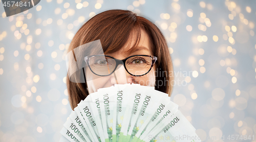 Image of senior woman with hundreds of euro money banknotes