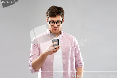 Image of surprised man in glasses looking at smartphone