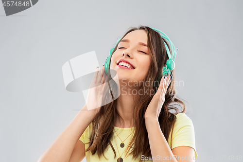 Image of happy young woman or teenage girl with headphones