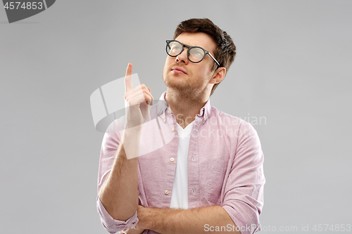 Image of young man in glasses pointing finger up