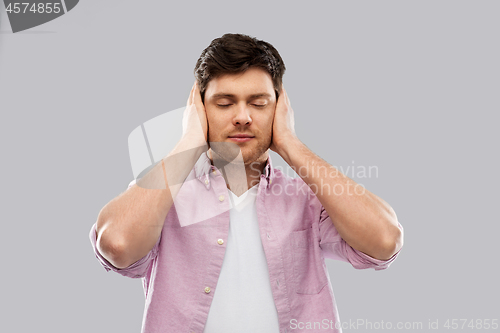 Image of man closing ears by hands