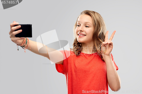 Image of smiling teenage girl taking selfie by smartphone