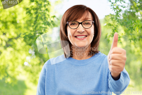 Image of portrait of senior woman showing thumbs up