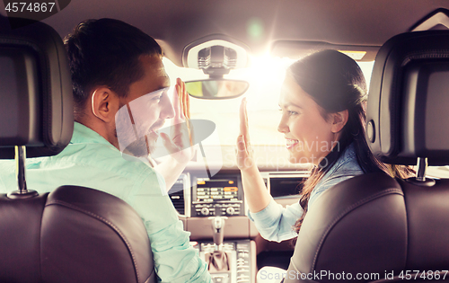 Image of happy man and woman driving in car