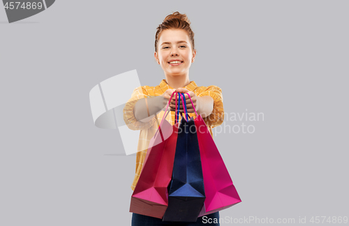 Image of smiling red haired teenage girl with shopping bags