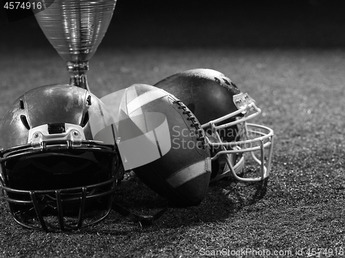 Image of closeup of american football,helmets and trophy