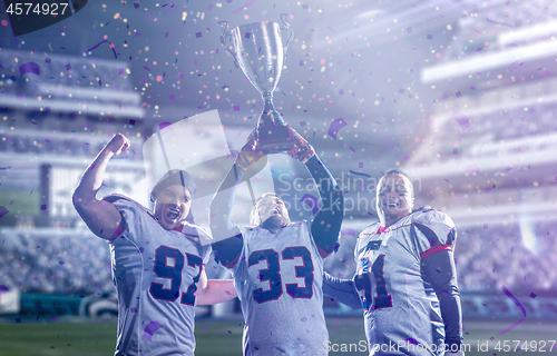 Image of american football team with trophy celebrating victory in the cu