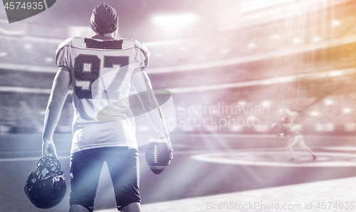 Image of rear view of young confident American football player on the fie