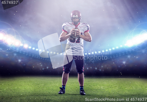 Image of portrait of confident American football player standing on the f