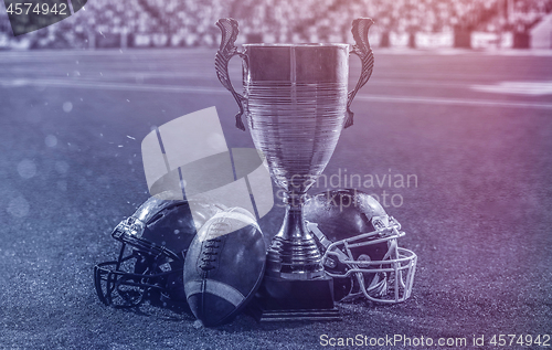 Image of closeup of american football,helmets and trophy