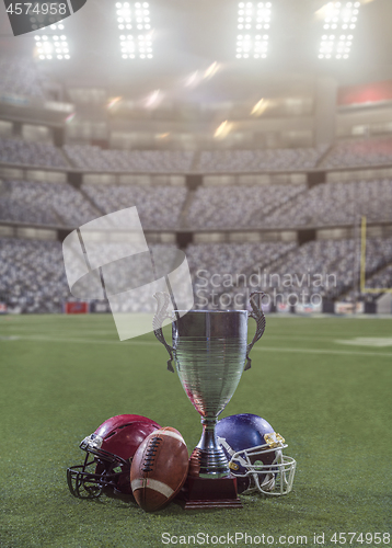 Image of closeup of american football,helmets and trophy