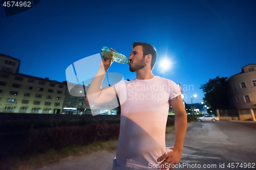 Image of man drinking water after running session