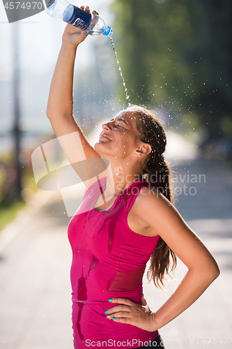 Image of woman pouring water from bottle on her head