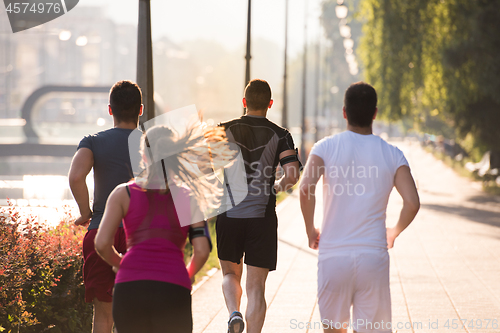 Image of group of young people jogging in the city