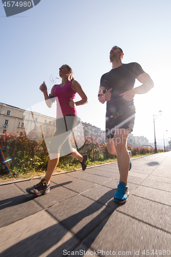 Image of young couple jogging  in the city