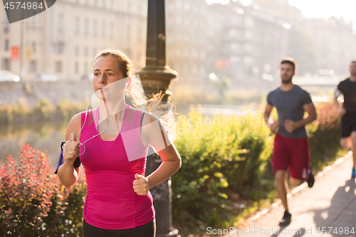 Image of group of young people jogging in the city