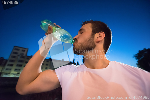 Image of man drinking water after running session