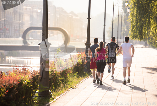 Image of group of young people jogging in the city