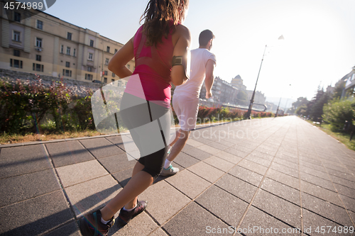 Image of young couple jogging  in the city