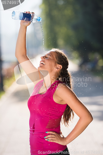 Image of woman pouring water from bottle on her head